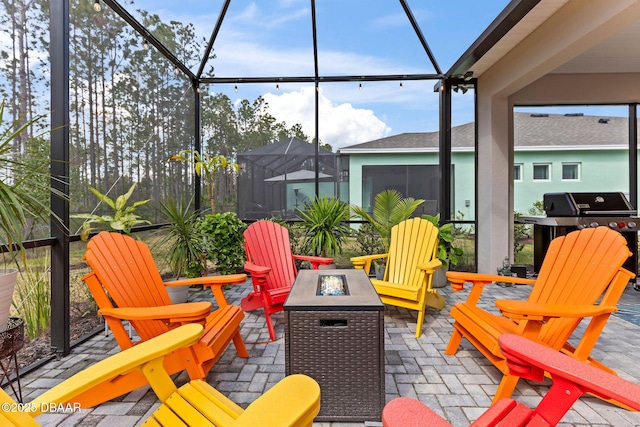 view of patio featuring area for grilling, glass enclosure, and a fire pit