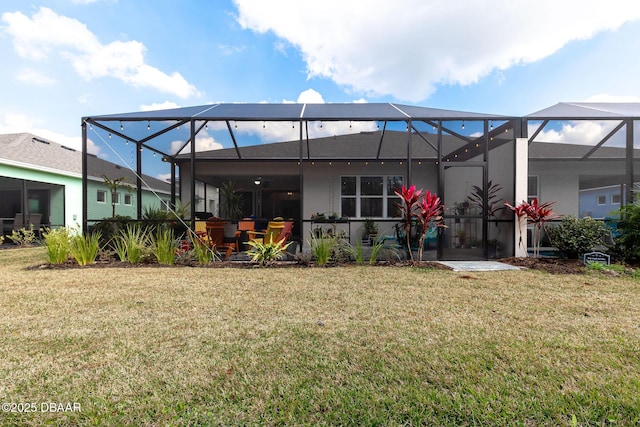 rear view of house with a lanai and a lawn