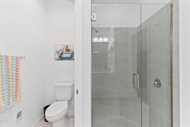 bathroom featuring toilet and a shower with shower door