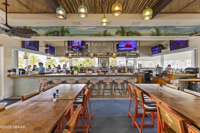 bar featuring a healthy amount of sunlight, wooden counters, and dark tile patterned floors