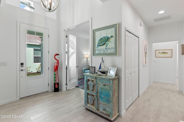 foyer entrance featuring a notable chandelier and light hardwood / wood-style flooring