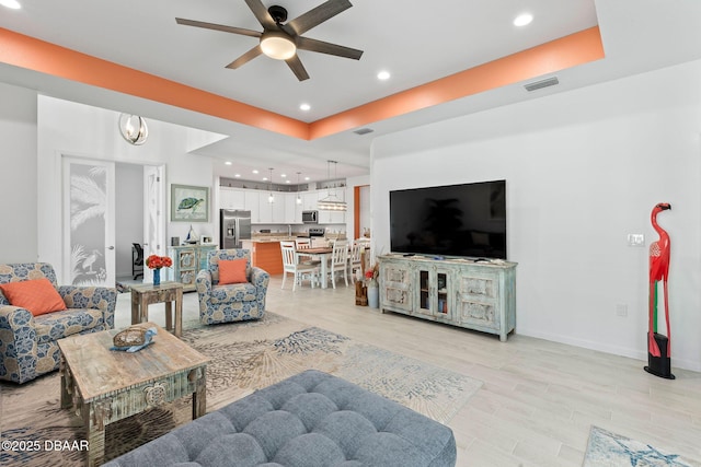 living room with ceiling fan and light wood-type flooring