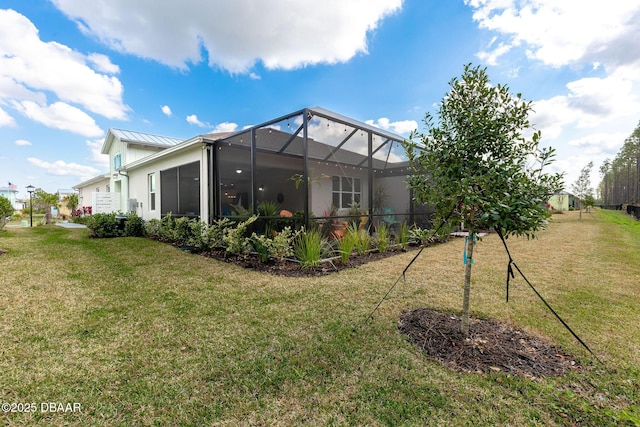 back of house with a yard and glass enclosure