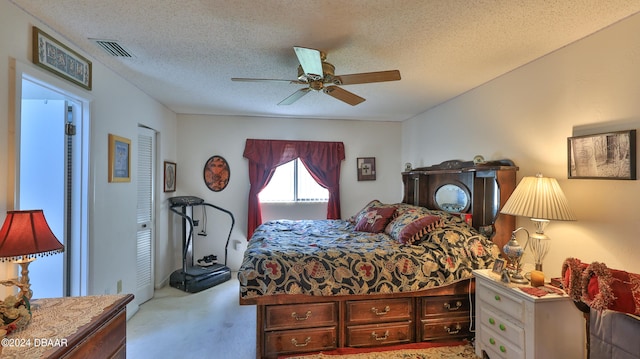 carpeted bedroom featuring a textured ceiling and ceiling fan