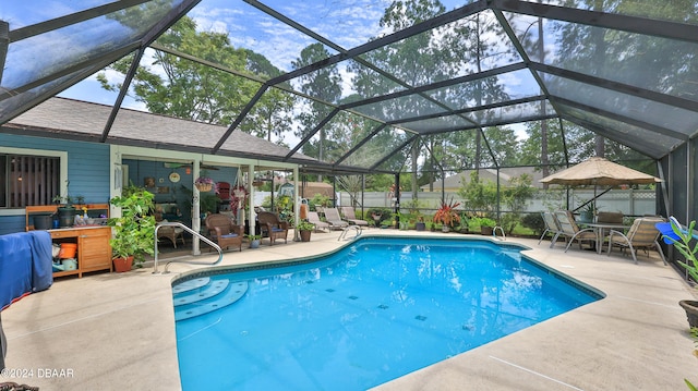 view of pool with glass enclosure and a patio area