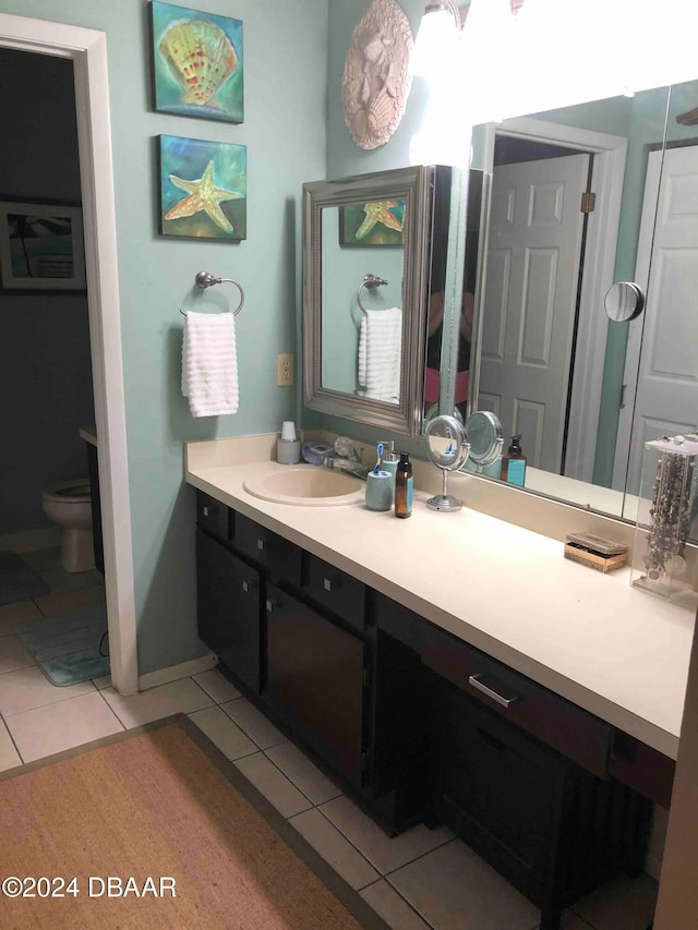 bathroom featuring tile patterned flooring, vanity, and toilet