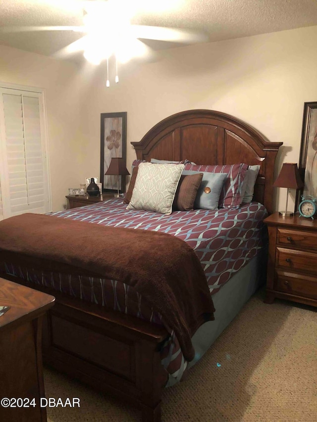 carpeted bedroom featuring a textured ceiling and ceiling fan