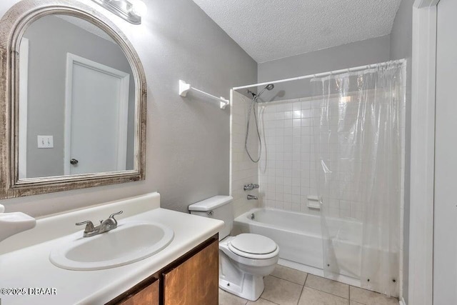 bathroom featuring tile patterned flooring, shower / bath combo with shower curtain, toilet, vanity, and a textured ceiling