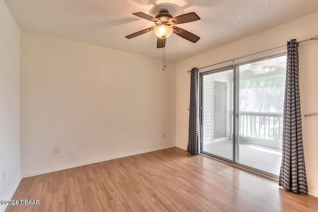 empty room with a ceiling fan, wood finished floors, and a textured ceiling