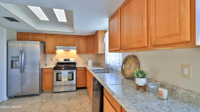 1107 Viking Dr, Port Orange, FL 32129 - kitchen with stainless steel appliances, under cabinet range hood, a sink, light stone counters, and brown cabinetry