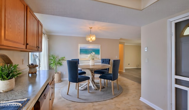 dining area with crown molding and an inviting chandelier