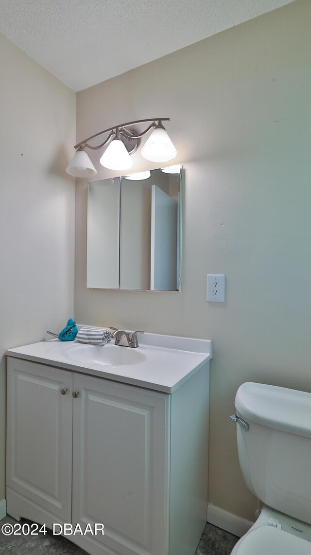 1107 Viking Dr, Port Orange, FL 32129 - half bathroom featuring vanity, toilet, baseboards, and a textured ceiling