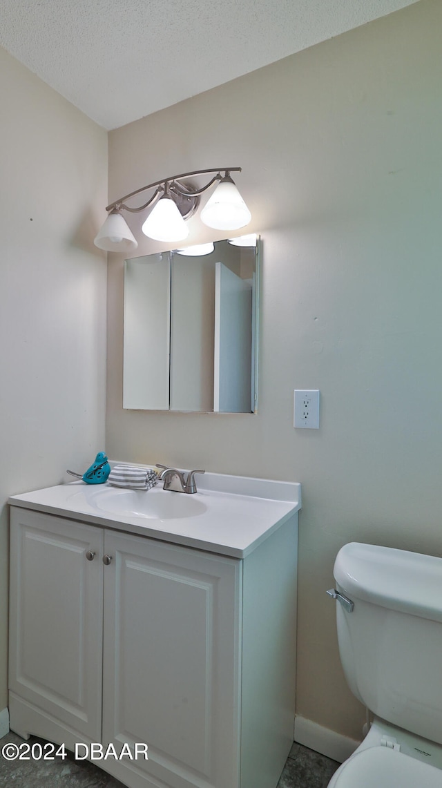 bathroom featuring vanity, toilet, and a textured ceiling