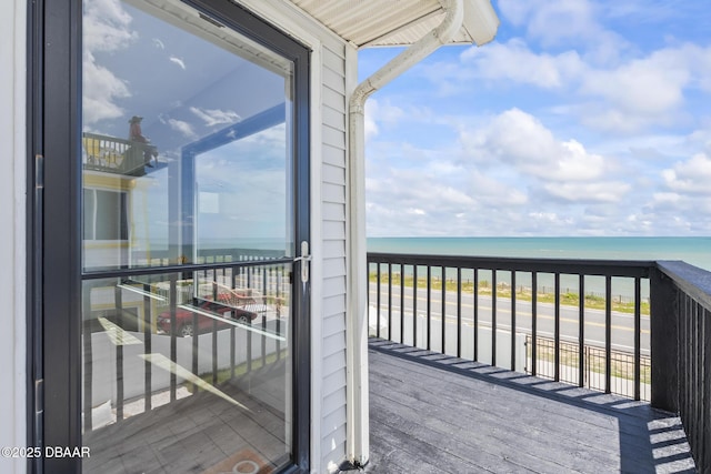 wooden deck with a water view and a beach view