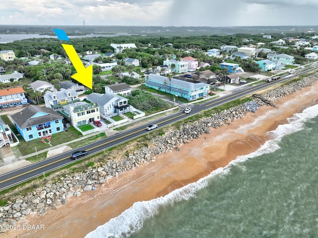 drone / aerial view with a water view and a beach view