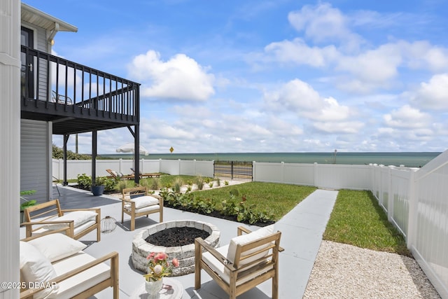 view of patio featuring a deck with water view and an outdoor fire pit