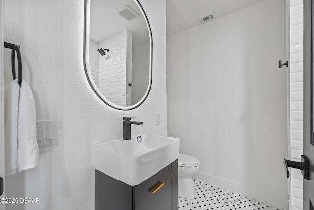 bathroom featuring a shower, vanity, and toilet