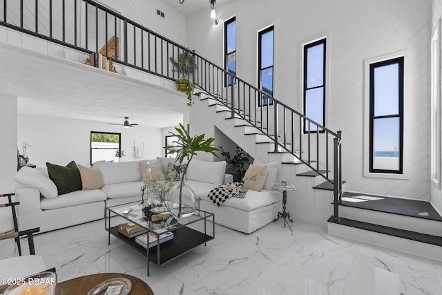 living room featuring a towering ceiling and ceiling fan