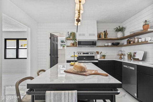 kitchen with light stone counters, a kitchen breakfast bar, a kitchen island, pendant lighting, and stainless steel appliances