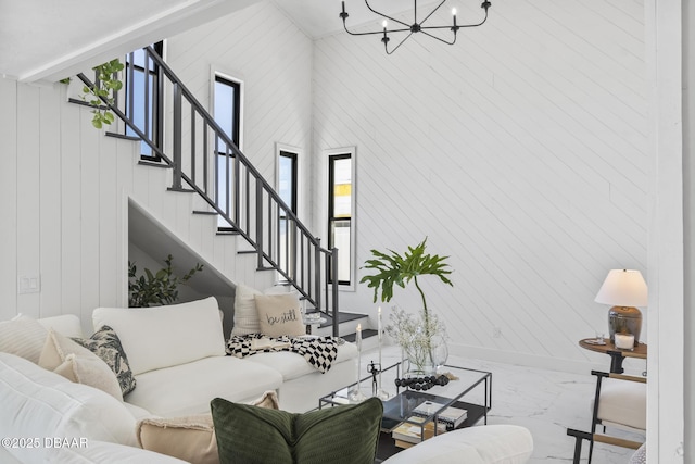 living room with a towering ceiling, a wealth of natural light, and a notable chandelier