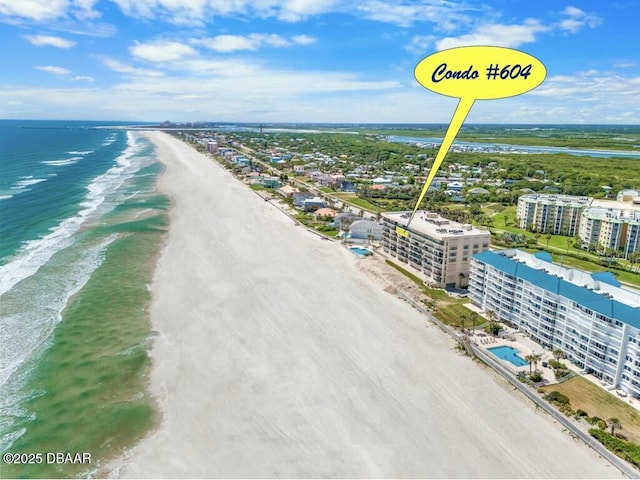 birds eye view of property with a water view and a beach view