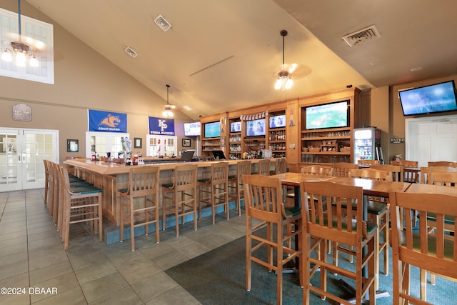 dining room featuring ceiling fan, tile patterned flooring, and high vaulted ceiling