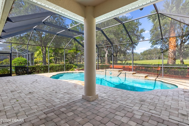 view of pool featuring glass enclosure and a patio area