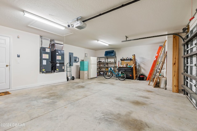 garage featuring a garage door opener, heating unit, and white refrigerator