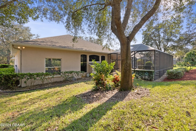 rear view of property featuring a yard and a lanai