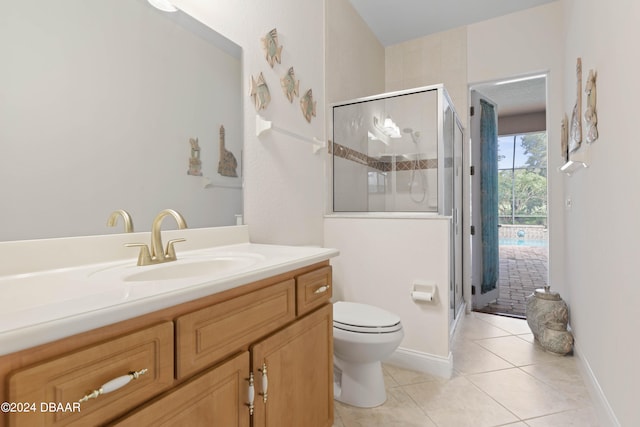 bathroom featuring toilet, vanity, tile patterned flooring, and a shower with shower door