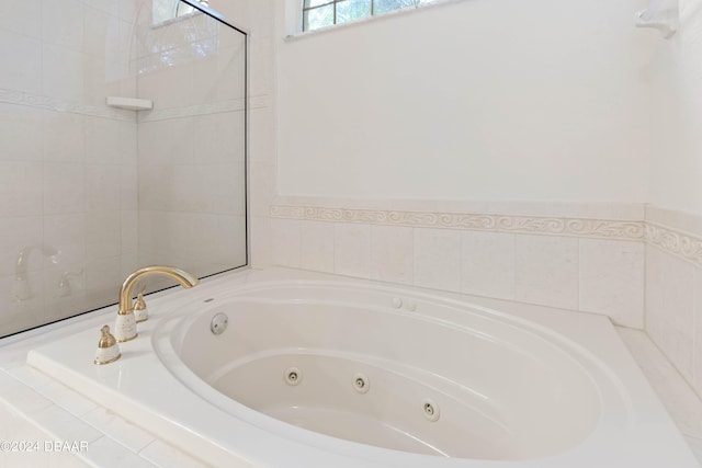 bathroom with a relaxing tiled tub