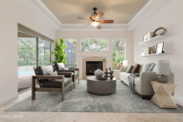 living room featuring light tile patterned floors, ceiling fan, and a raised ceiling