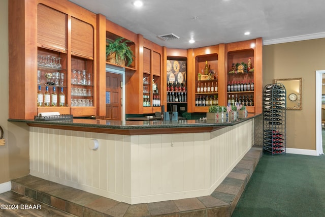 bar featuring ornamental molding and dark colored carpet