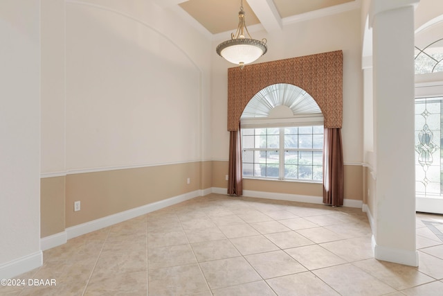 tiled spare room featuring beamed ceiling