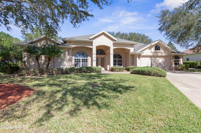 view of front of home with a garage and a front lawn