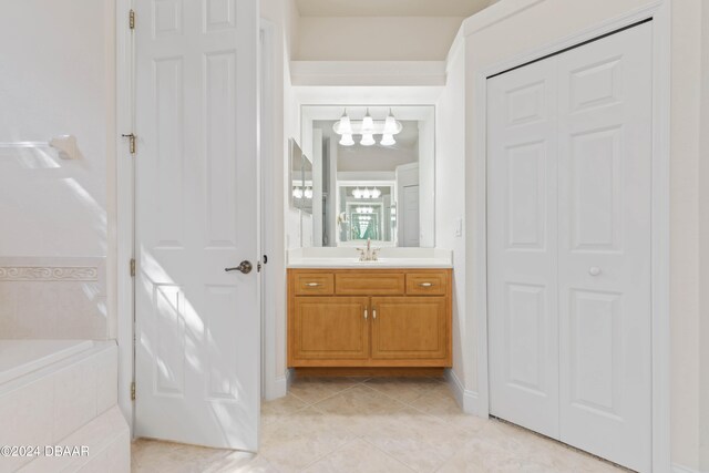 bathroom with vanity, tile patterned flooring, and tiled tub