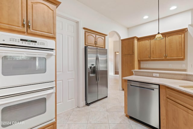 kitchen featuring stainless steel appliances, hanging light fixtures, and light tile patterned floors