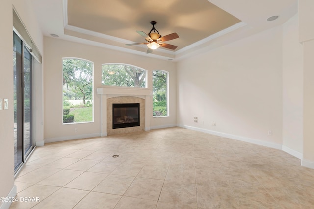 unfurnished living room with ceiling fan, a raised ceiling, and light tile patterned floors