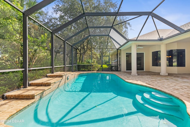 view of swimming pool featuring ceiling fan, glass enclosure, and a patio area