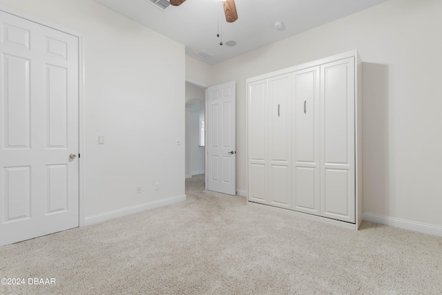 unfurnished bedroom featuring light carpet and ceiling fan