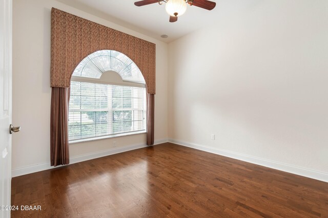 unfurnished room featuring dark hardwood / wood-style floors and ceiling fan