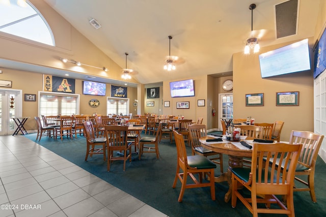 dining room featuring ceiling fan, tile patterned flooring, and high vaulted ceiling