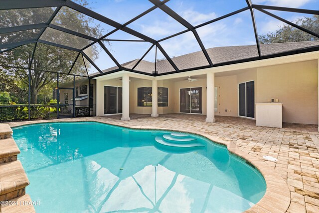 view of pool with ceiling fan, a lanai, and a patio area