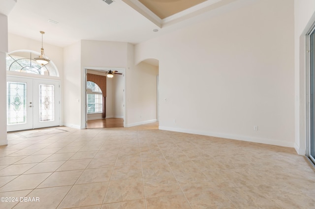 entrance foyer featuring a high ceiling, ceiling fan, light tile patterned floors, and french doors