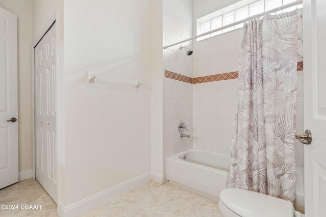 bathroom with tile patterned flooring, shower / bath combo, and toilet