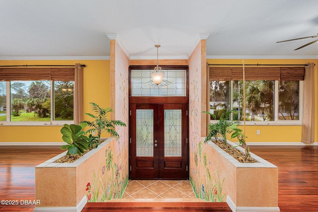 entrance foyer with wood finished floors and crown molding