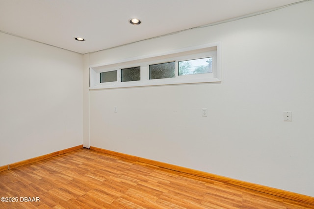 spare room featuring recessed lighting, light wood-style flooring, and baseboards