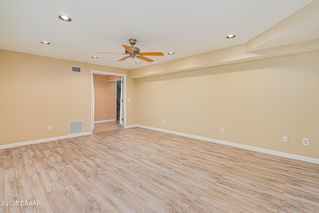 empty room featuring light wood finished floors, baseboards, and visible vents