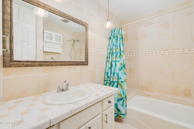 full bathroom with shower / tub combo, visible vents, vanity, tile walls, and backsplash