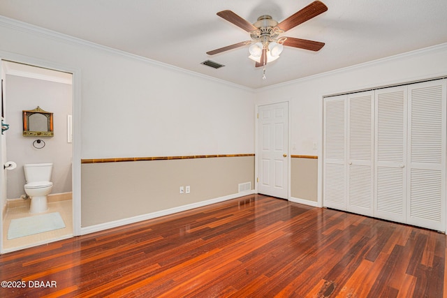 unfurnished bedroom with baseboards, visible vents, wood finished floors, and ornamental molding